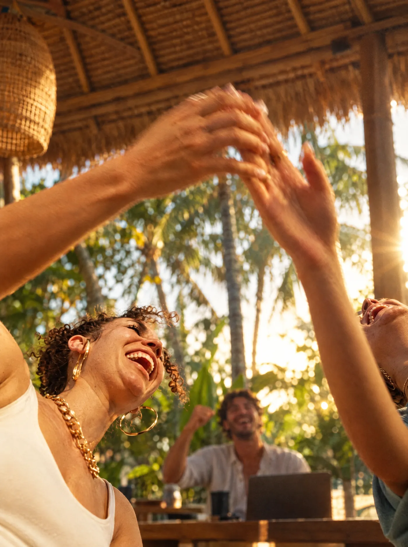 Two teammates high-fiving after a closed deal in an open-air Bali office